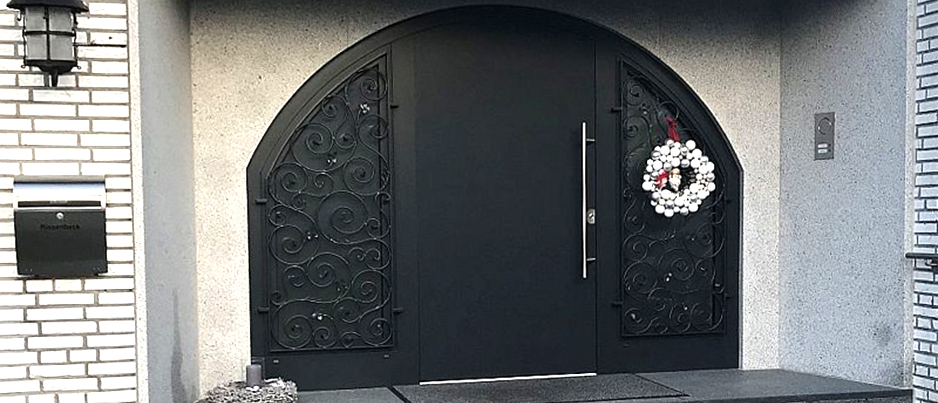 Herkenhoff Referenzen große schwarze Haustür mit Ornamenten